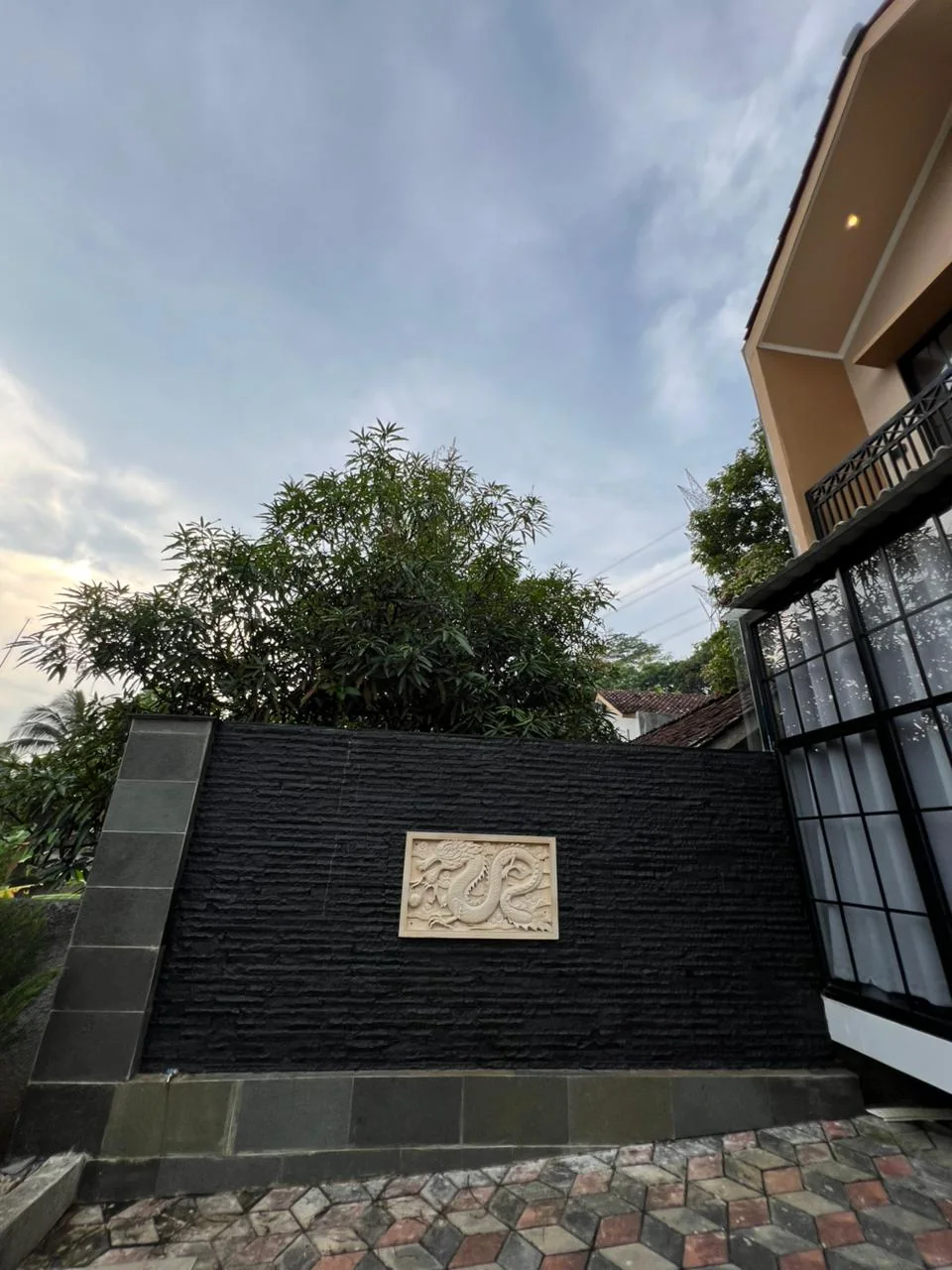 Dinding batu alam hitam dengan panel relief