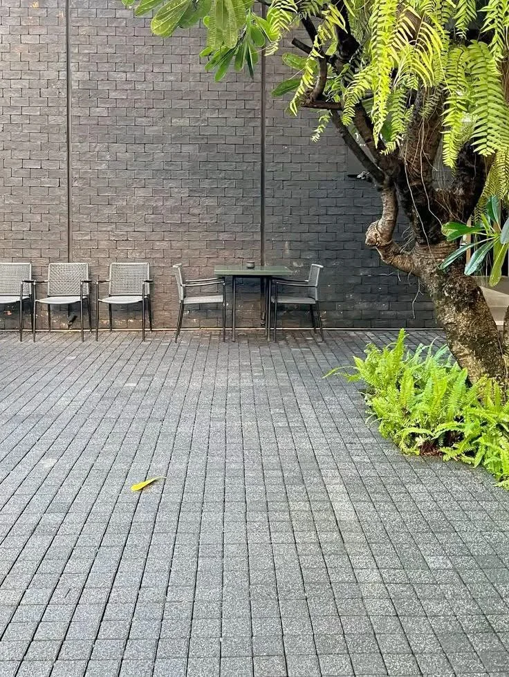 Lantai outdoor abu dengan area duduk dan tanaman